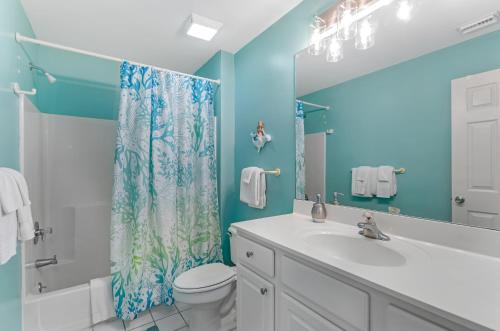 a bathroom with a sink and a shower curtain at South Beach Views in Tybee Island