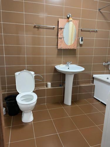 a bathroom with a toilet and a sink at Уютная квартира на левом берегу Астаны in Taldykolʼ