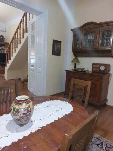 a dining room with a table with a vase on it at Apartman Dane in Kikinda