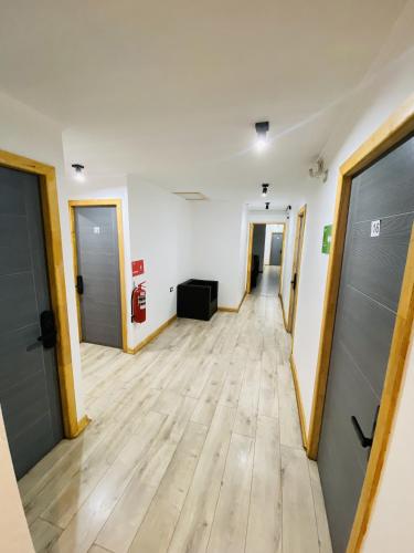 an empty hallway of an office with doors and wooden floors at VOY Hostales - 4 Norte in Viña del Mar