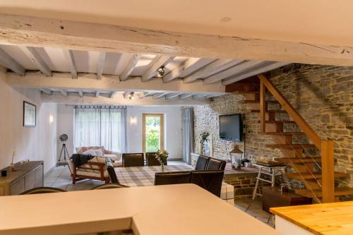 a living room with a stone wall at Gîte de charme à la campagne in Coësmes