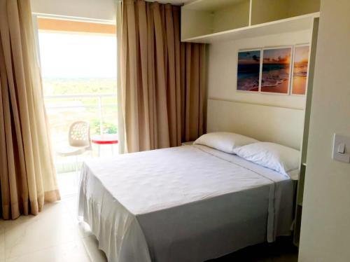a bedroom with a bed and a large window at Fortaleza Sul Flats Service in Fortaleza