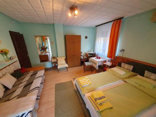 a bedroom with two beds and a living room at Pereszlényi Vendégház in Visegrád