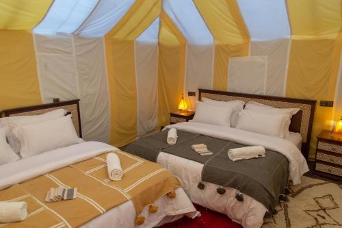 2 Betten in einem Zimmer mit Zelt in der Unterkunft Zahra Luxury Desert Camp in Merzouga