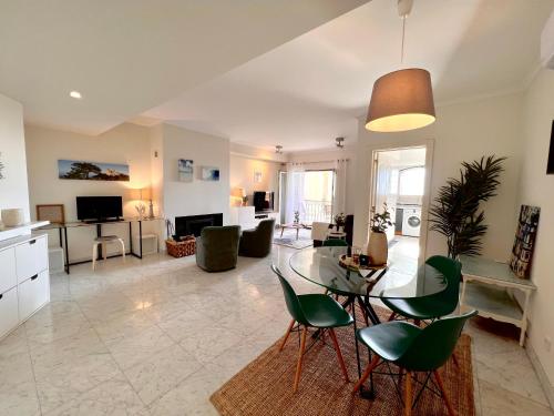 a living room with a table and green chairs at Lux Cascais Ocean View in Parede