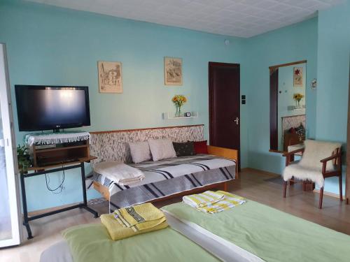 a room with two beds and a flat screen tv at Pereszlényi Vendégház in Visegrád