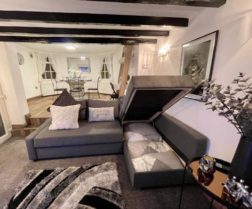 a living room with a couch and a table at Tollgate House - Luxury Cozy Cottage - HUGE Hot Tub - Alton Towers in Cheadle
