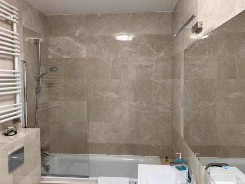 JAB Apartament Przy Klinice Business & Family في شتتين: حمام مع حوض استحمام ومغسلة