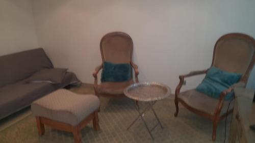 un soggiorno con 2 sedie e un divano di 5 Rue Adeline a Pierrefitte-sur-Seine