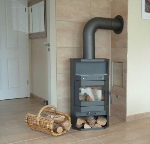 a wood stove with logs in a room at Appartement Sundevit in Börgerende-Rethwisch