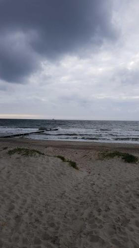 a beach with the ocean on a cloudy day at Appartement Sundevit in Börgerende-Rethwisch