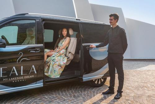 a man standing next to a van with a woman in the door at EALA My Lakeside Dream - Adults Only in Limone sul Garda