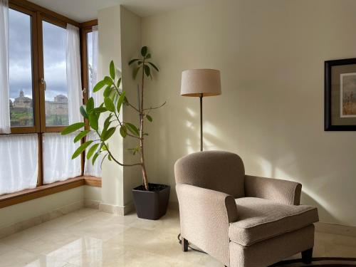 a living room with a chair and a potted plant at Parador de Puebla de Sanabria in Puebla de Sanabria