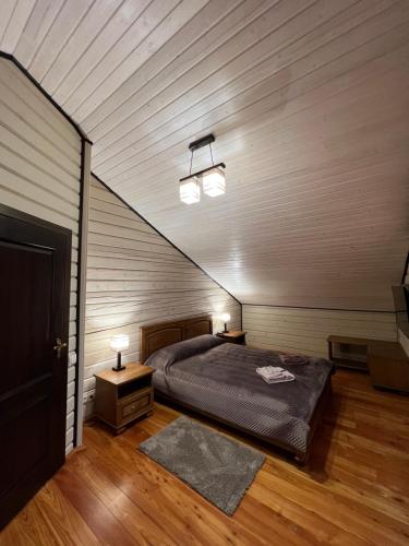 a bedroom with a bed and two night stands and two lamps at Villa Family House Truskavets in Modrychi