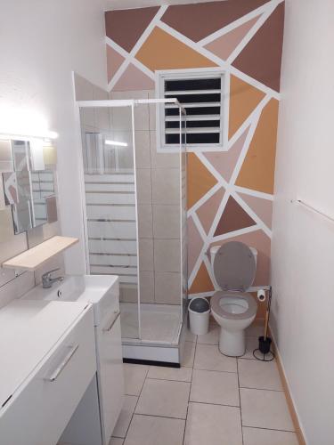 een badkamer met toilet en glazen douche bij Villa in Baie Mahault