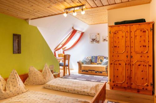 ein Wohnzimmer mit einem Bett und einem Sofa und ein Zimmer mit in der Unterkunft Pension Holzmeister in Sankt Kathrein am Offenegg