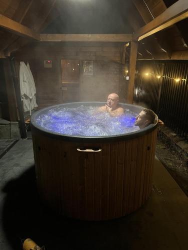 two people in a hot tub with blue water at Willa Nad Wodospadem in Szczawnica