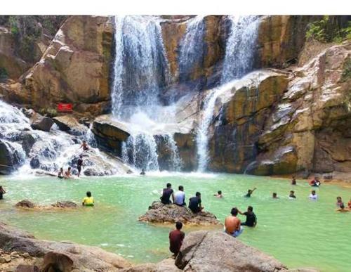 a group of people in the water near a waterfall at 1 min to Seaview & Sunrise Heart of Kuantan in Kuantan