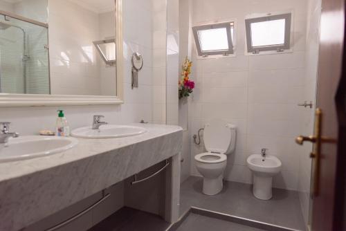 een witte badkamer met 2 wastafels en een toilet bij VILLA MATI Maison D'hôtes in Tetouan