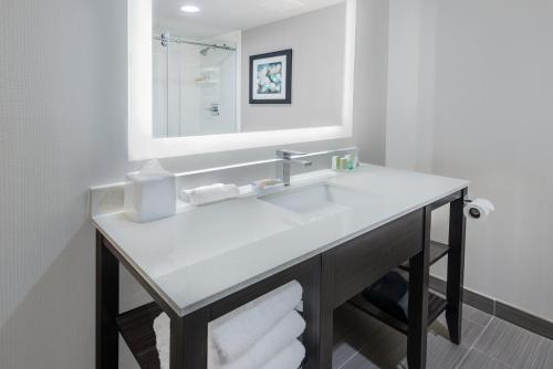 Holiday Inn - Beaumont East-Medical Ctr Area, an IHG Hotel في بومونت: حمام مع حوض أبيض ومرآة