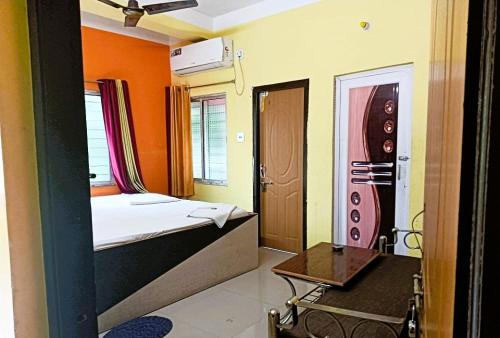 een kleine kamer met een bed en een tafel. bij Trinayani Stay - 3 min Walk to Temple in Tarapith