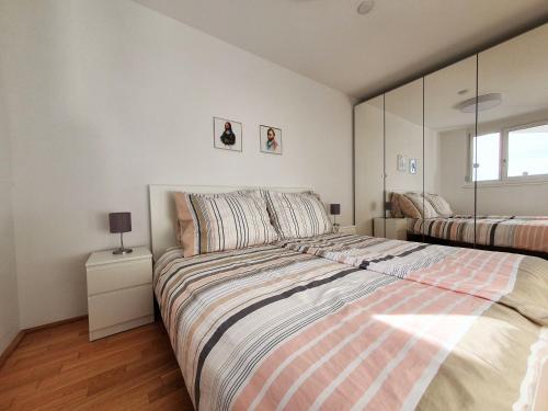 een slaapkamer met een groot bed en een gestreepte deken bij Near Lake Stylish & Fully Furnished Apartment in Wenen