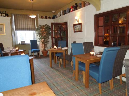 a dining room with tables and blue chairs at Troutbeck Inn in Troutbeck