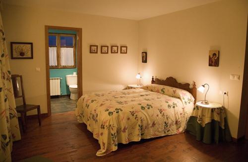 a bedroom with a bed and a bathroom at Hotel Rural La Peregrina in Carucedo