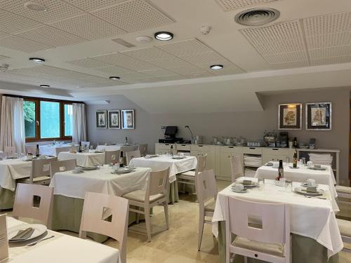a dining room with white tables and white chairs at Parador de Puebla de Sanabria in Puebla de Sanabria