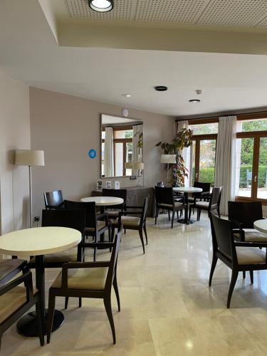 a waiting room with tables and chairs and windows at Parador de Puebla de Sanabria in Puebla de Sanabria