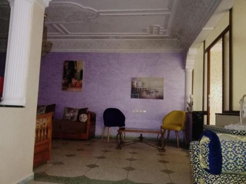 a room with purple walls and two chairs and a table at appartement haut standing in Salé