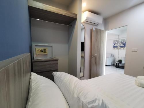 a bedroom with a white bed and a tv at ABC@48 Hotel & Service Apartment in Bangkok