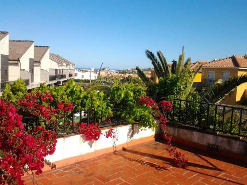 a balcony with red flowers and plants on a building at House near beach in Peñíscola for 4 in Peñíscola
