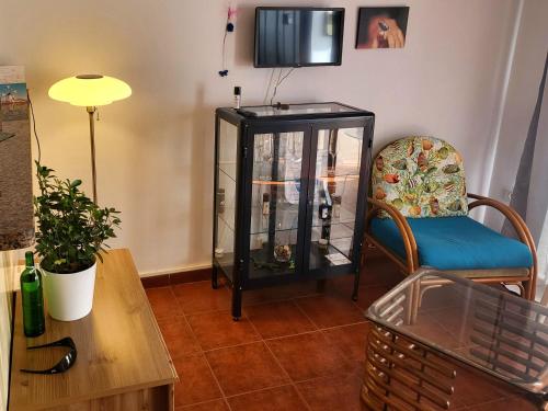 een woonkamer met een aquarium en een stoel bij casa mariposa in Playa de Santiago