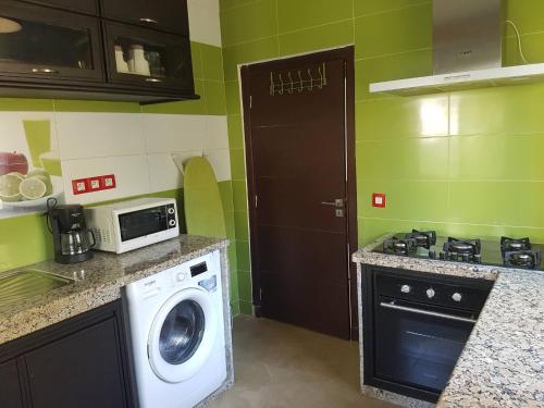 uma cozinha com uma máquina de lavar roupa e um micro-ondas em Nice Apartment For Families- Bd Ghandi- Casablanca em Casablanca