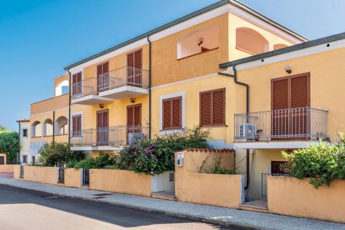 a yellow building with balconies on a street at Apartments in Santa Teresa di Gallura in Santa Teresa Gallura