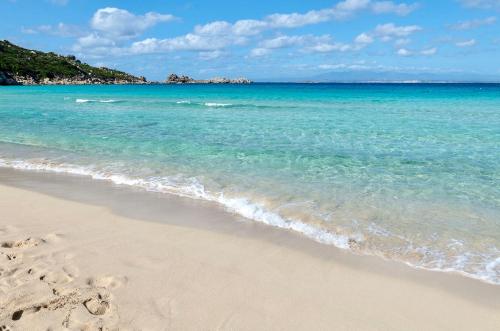 una spiaggia con impronte di piedi nella sabbia e nell'oceano di Apartments in Santa Teresa di Gallura a Santa Teresa di Gallura