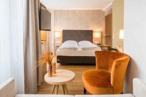 Hotel Flandrischer Hof في كولونيا: غرفه فندقيه بسرير وكرسي