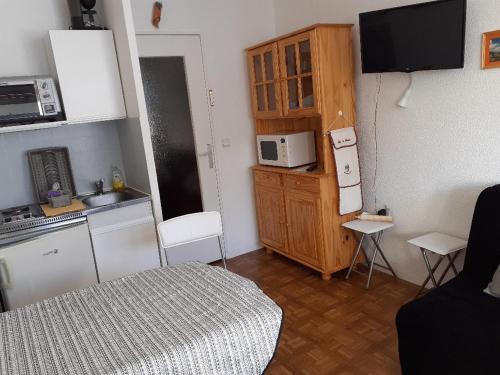 a small kitchen with a bed and a microwave at Studio au Sauze avec balcon, parking et équipements tout confort - FR-1-165A-114 in Enchastrayes