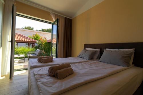 a bedroom with a large bed with towels on it at Sea Cats' Villas in Sutivan