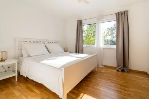 een witte slaapkamer met een groot bed en een raam bij Near Lake Fully Furnished Beautiful Apartment in Wenen