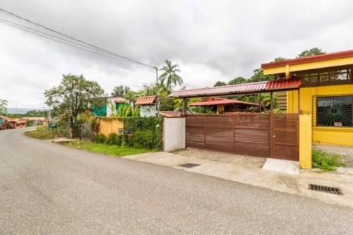 a yellow house on the side of a road at Hospedaje Poly in Río Claro