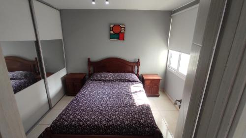 Dormitorio pequeño con cama y espejo en Apartamento Allegro en Córdoba