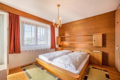 um quarto com uma cama e uma janela em Adang Ferienwohnung Etschtal em Tirolo
