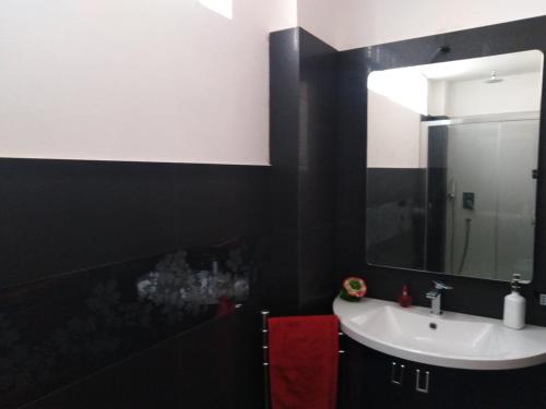 a black and white bathroom with a sink and a mirror at CASA MARY in Menfi