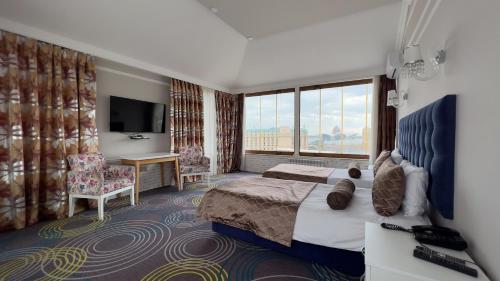 een hotelkamer met een bed en een televisie bij Qala Hotel in Baku