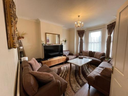 uma sala de estar com sofás e uma televisão de ecrã plano em Beautiful 3 bed apartment in Cricklewood em Londres