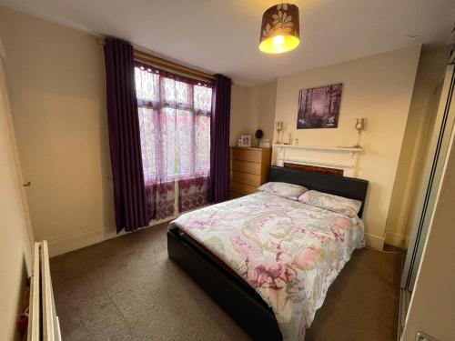 um quarto com uma cama e uma janela em Beautiful 3 bed apartment in Cricklewood em Londres