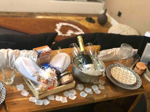 a table with wine bottles and other items on it at Le TULUM, T2, Hyper-centre, Place aux herbes in Mâcon