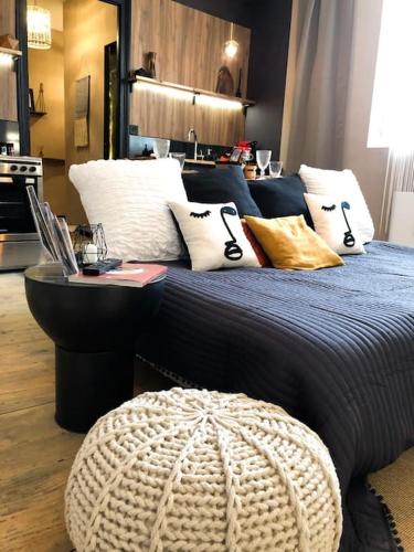 une chambre avec un grand lit avec des oreillers dessus dans l'établissement Le TULUM, T2, Hyper-centre, Place aux herbes, à Mâcon